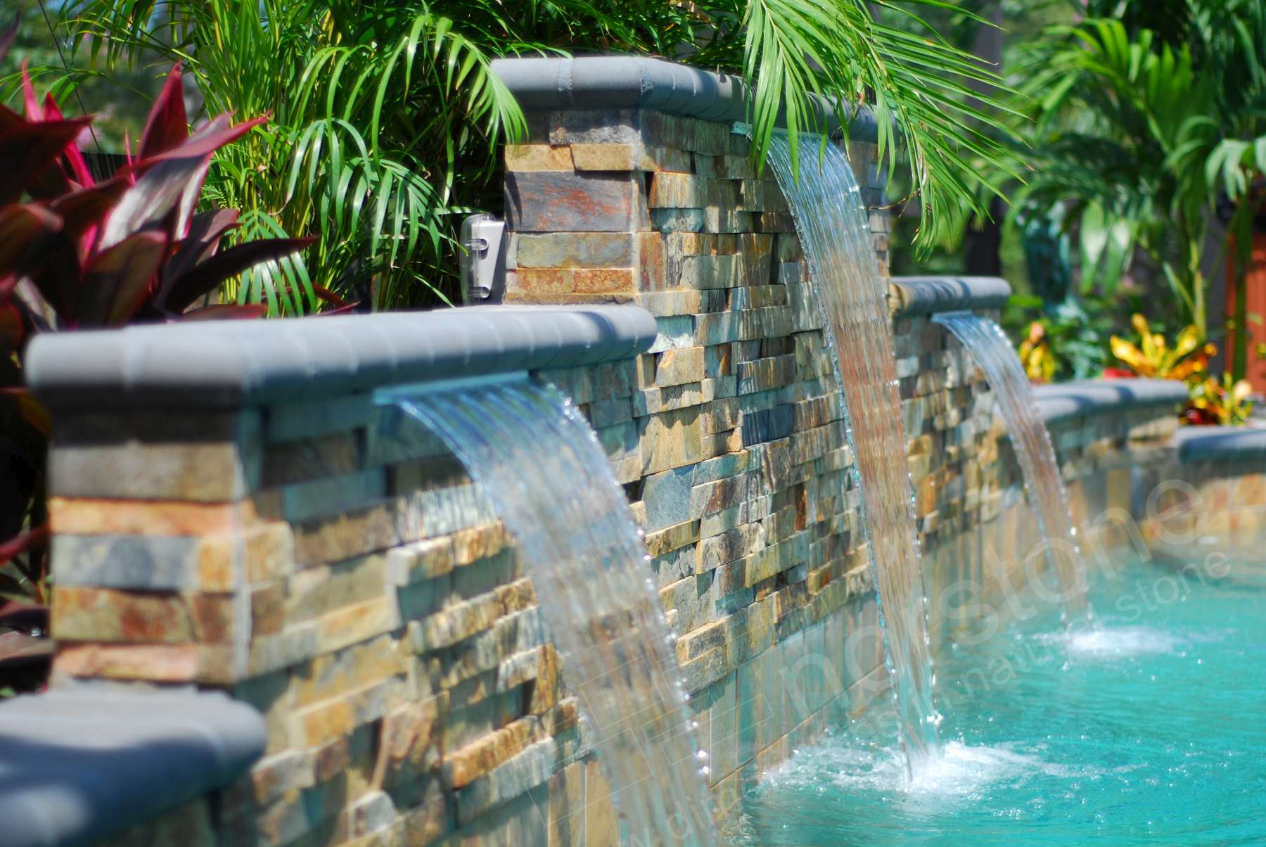 Side View of Norstone Ochre XL Stacked Stone Panels used on a pool raised beam water feature with three tiers showing miter cut outside corners